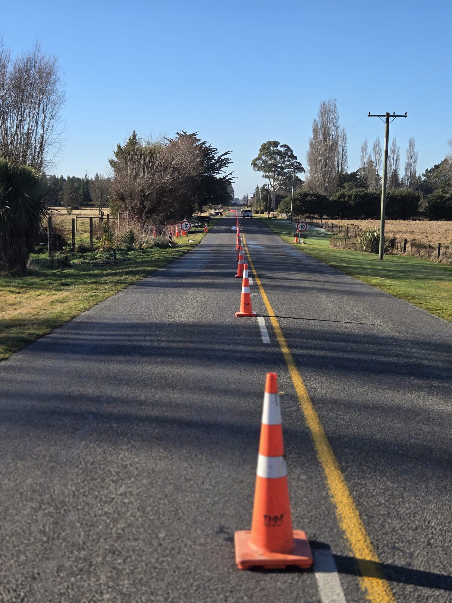 A controlled rural road work zone marked by a clear line of traffic cones